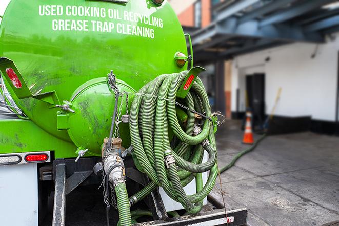 a technician pumping a grease trap in a commercial building in Forestville